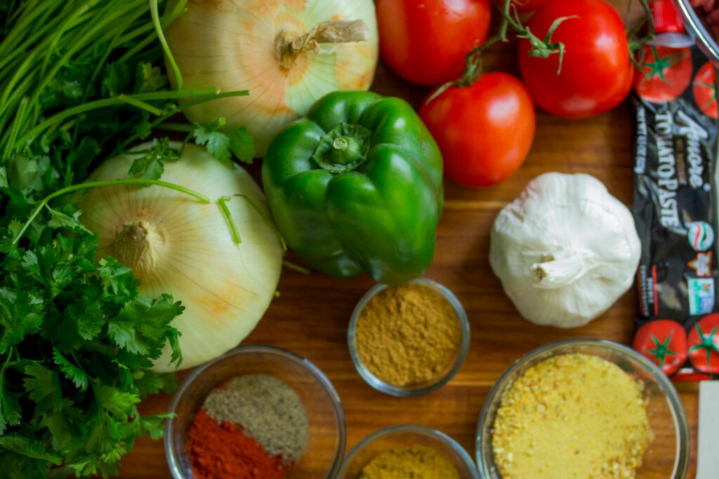 pexels-photo-128402-128402 An assortment of fresh vegetables and spices on a wooden table for healthy cooking.